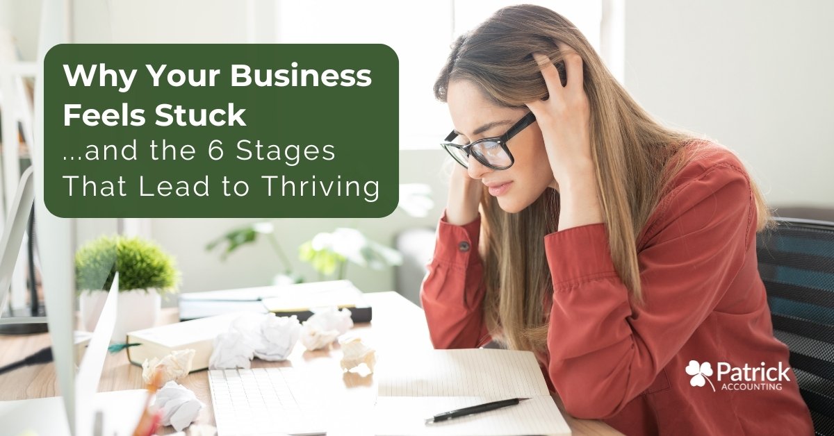 Business owner sitting at a desk looking stressed and overwhelmed, illustrating why a business feels stuck and the stages needed to move toward growth and stability.