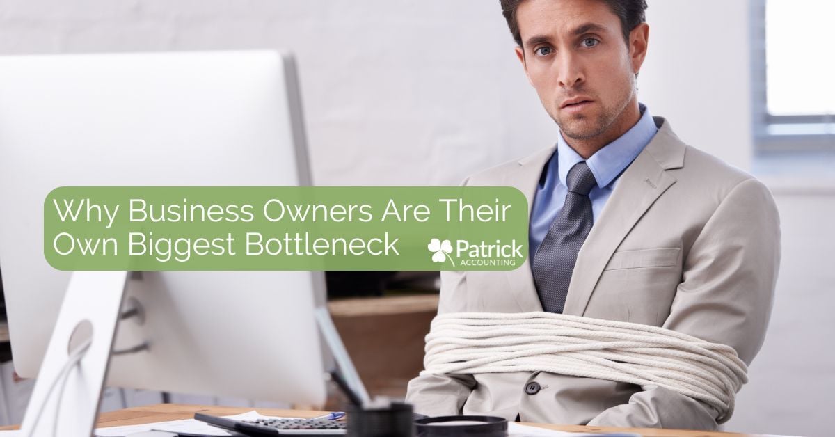 A man in a light gray suit sits at a desk with his arms tied to his sides with a thick white rope, symbolizing being stuck or restricted. He looks directly at the camera with a serious expression. Text overlay reads, 