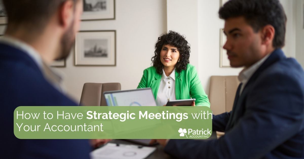 Two professionals meet with an accountant in a bright office. The accountant, wearing a green jacket, smiles while discussing documents. Text overlay reads, 