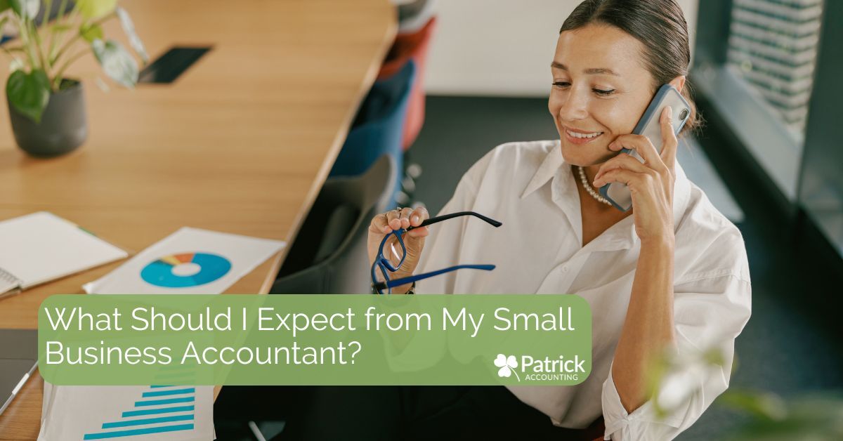 Smiling woman accountant holding glasses while talking on the phone in an office, with papers showing charts on the desk. Text overlay reads