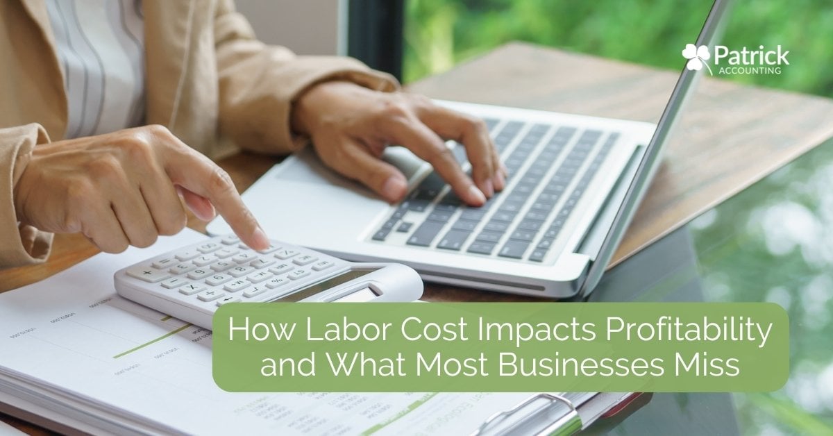 Small business owner calculating expenses on calculator and laptop, analyzing labor costs and profitability.
