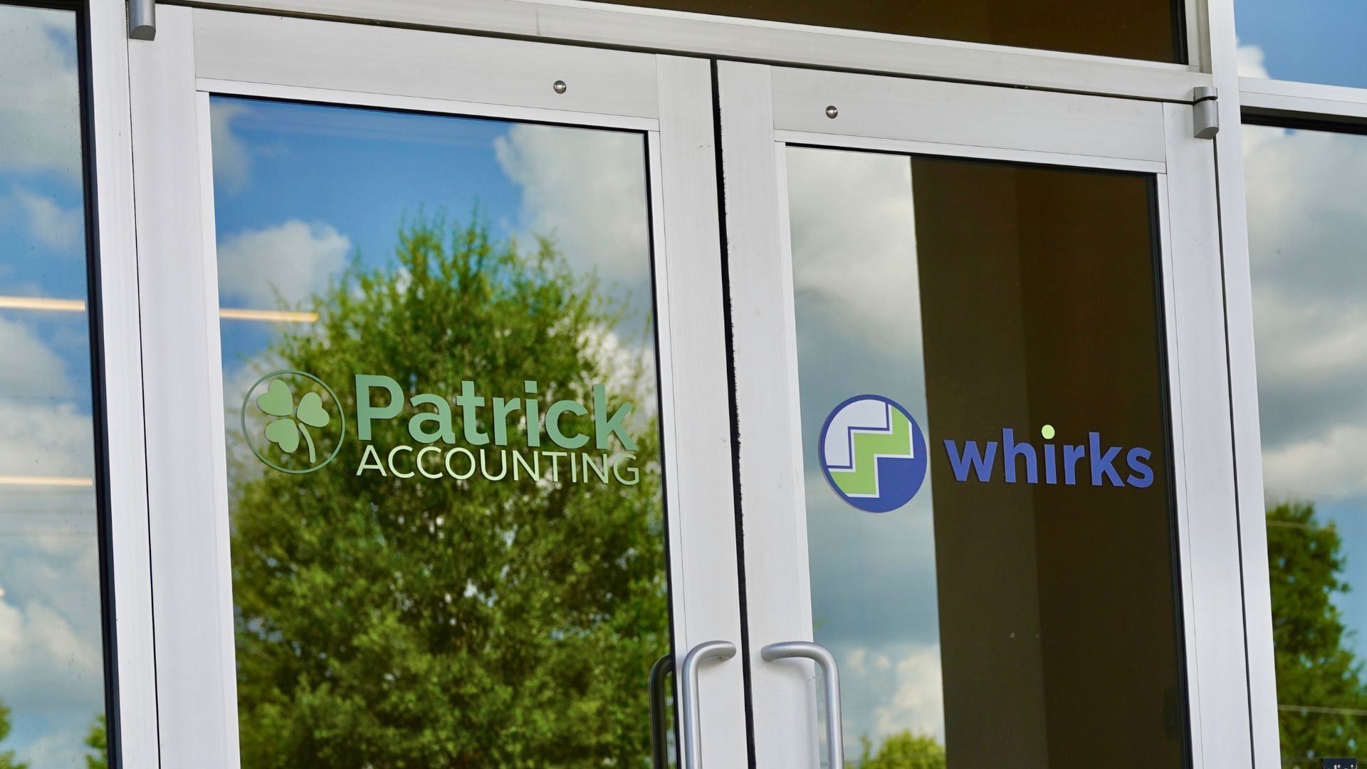 Photo of Patrick Accounting and Whirks new office front doors with both logos at the new location at 7345 Goodlett Farms Pkwy in Cordova, Tennessee. 
