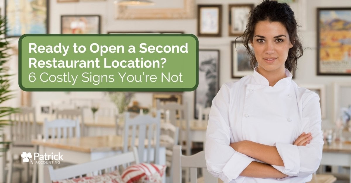Restaurant owner evaluating expansion, standing in dining space, illustrating considerations and risks of opening a second location.
