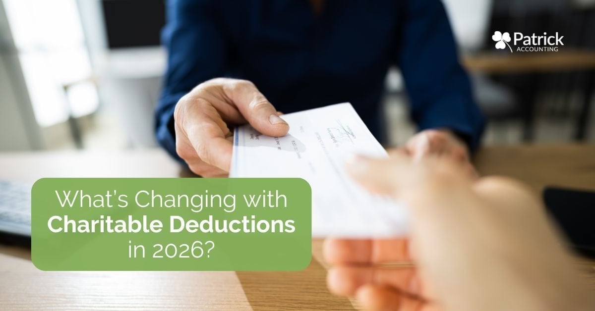 Person handing a donation check to another individual, illustrating charitable giving, tax-deductible donations, and changes to charitable deduction rules for taxpayers and small businesses in 2026.